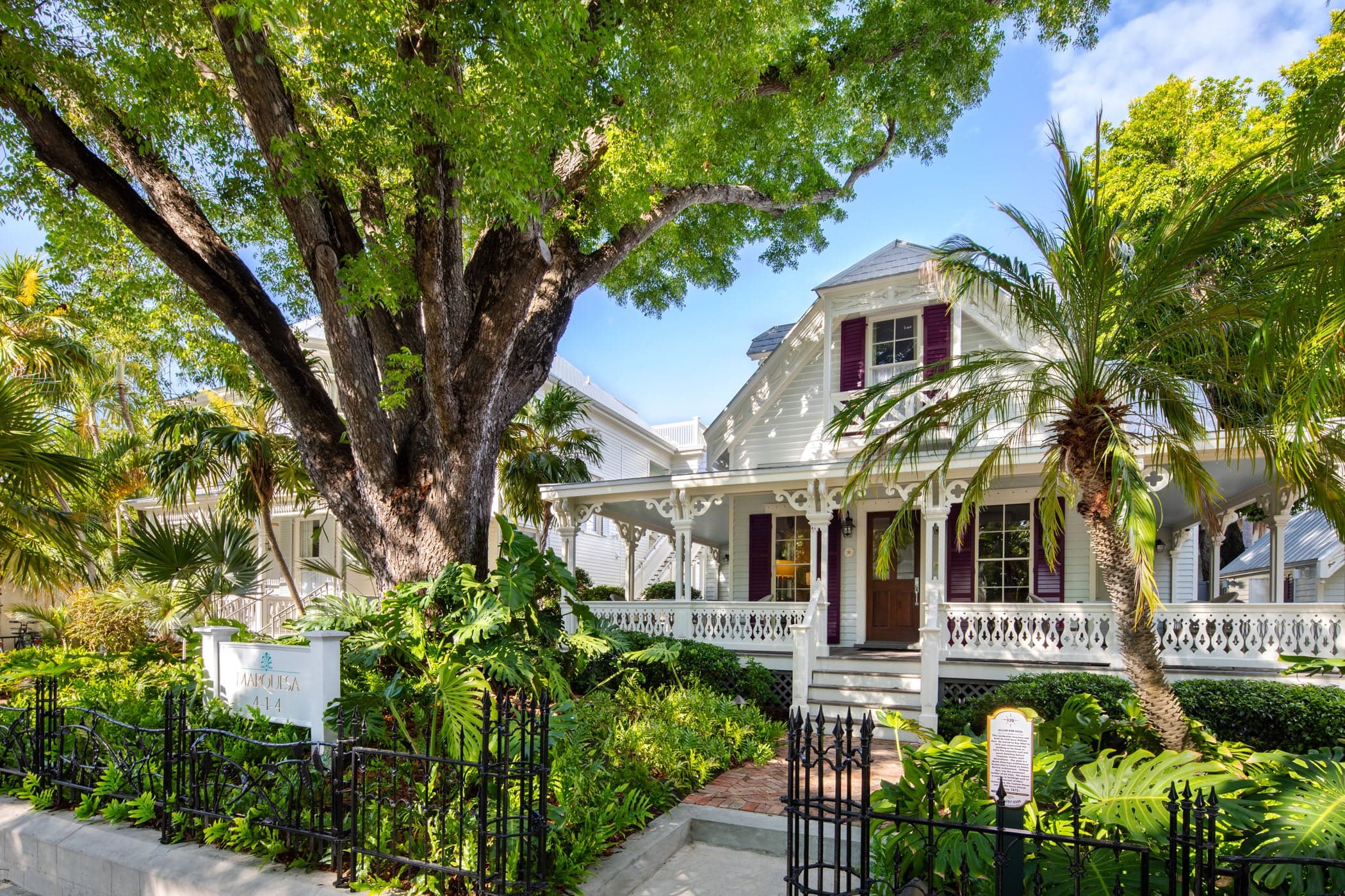 The exterior of Marquesa hotel with beautiful palm trees and other foliage