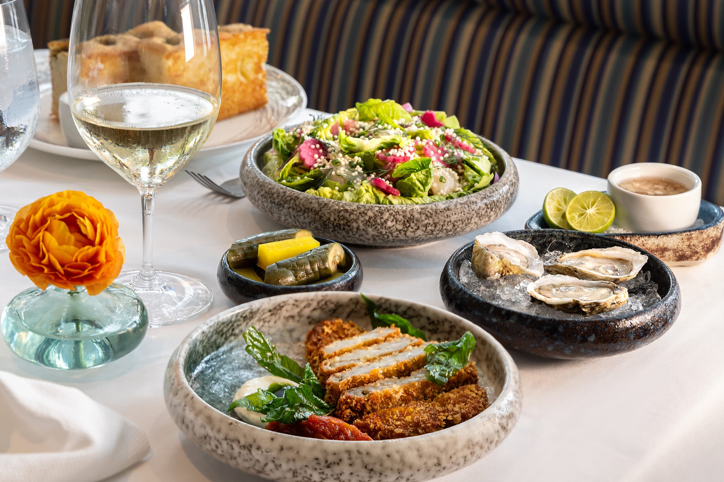 Dinner spread of oysters, salad, and crispy pork katsu at Cafe Marquesa in Key