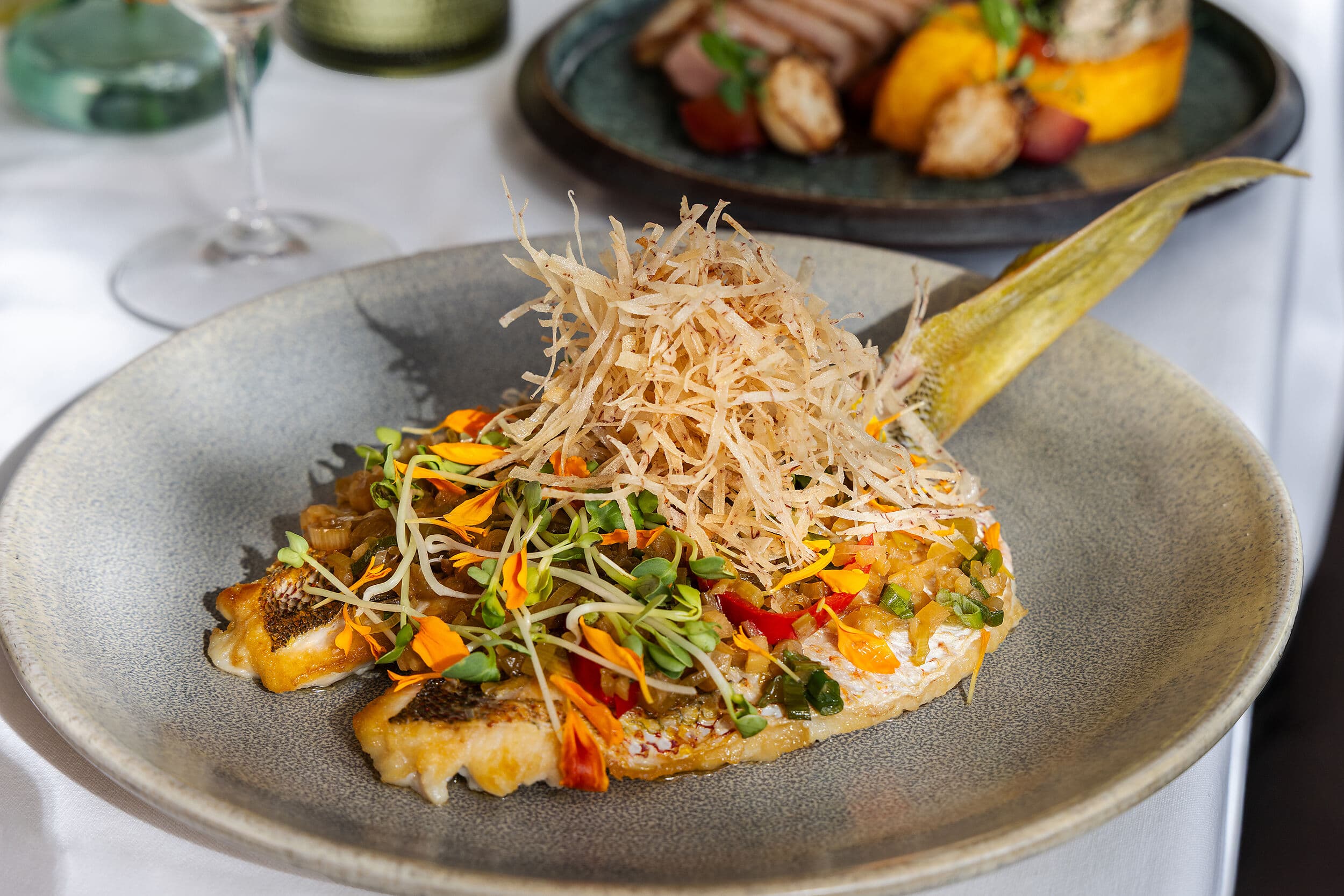 Crispy snapper entrée with edible flowers and shoestring potatoes at Cafe Marquesa, Key West