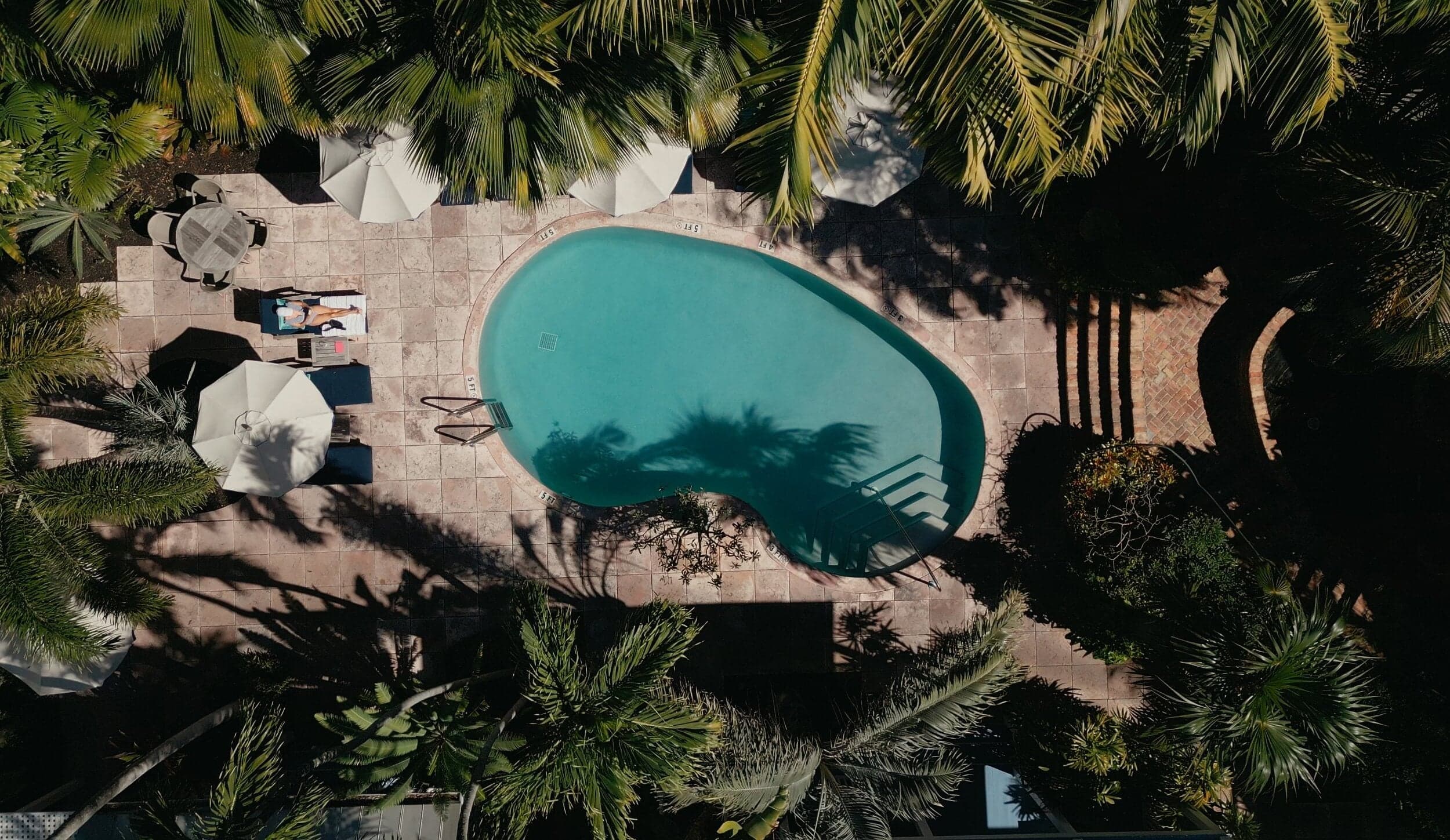 Aerial view of the palm-shaded pool and sun deck at The Marquesa Hotel in Key West, Florida