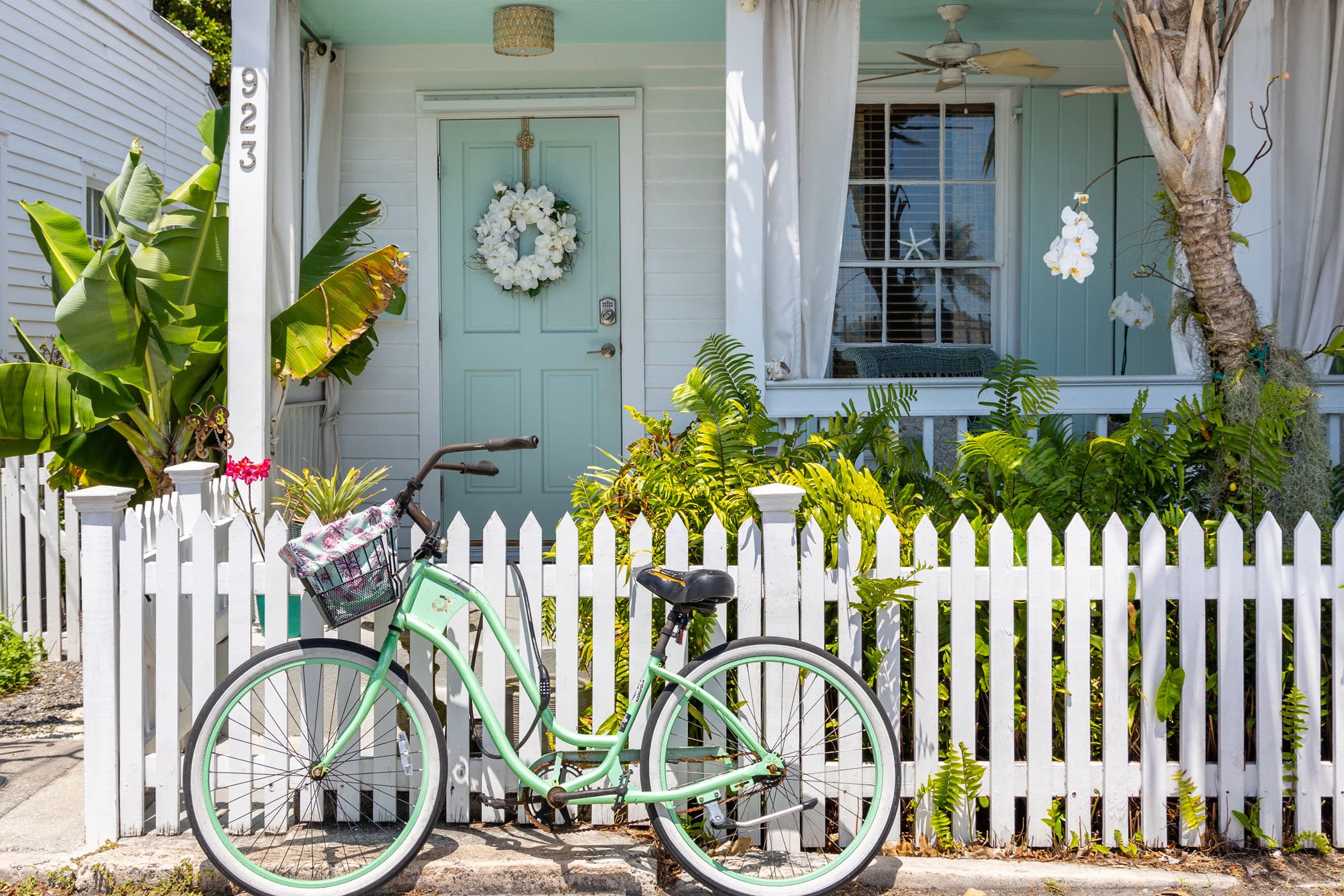 Bike & Basket leaning against a fence in front of a house