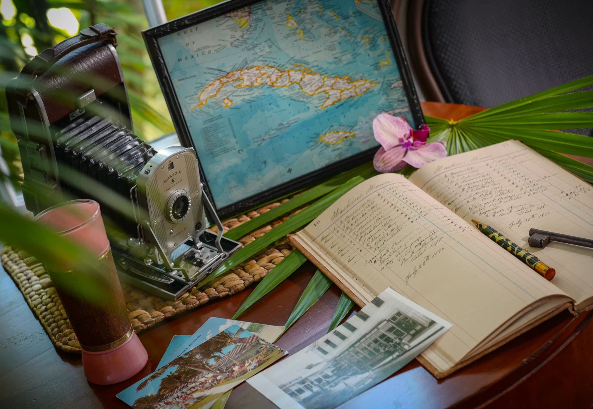 A table with a vintage camera, log book and a map of Key West