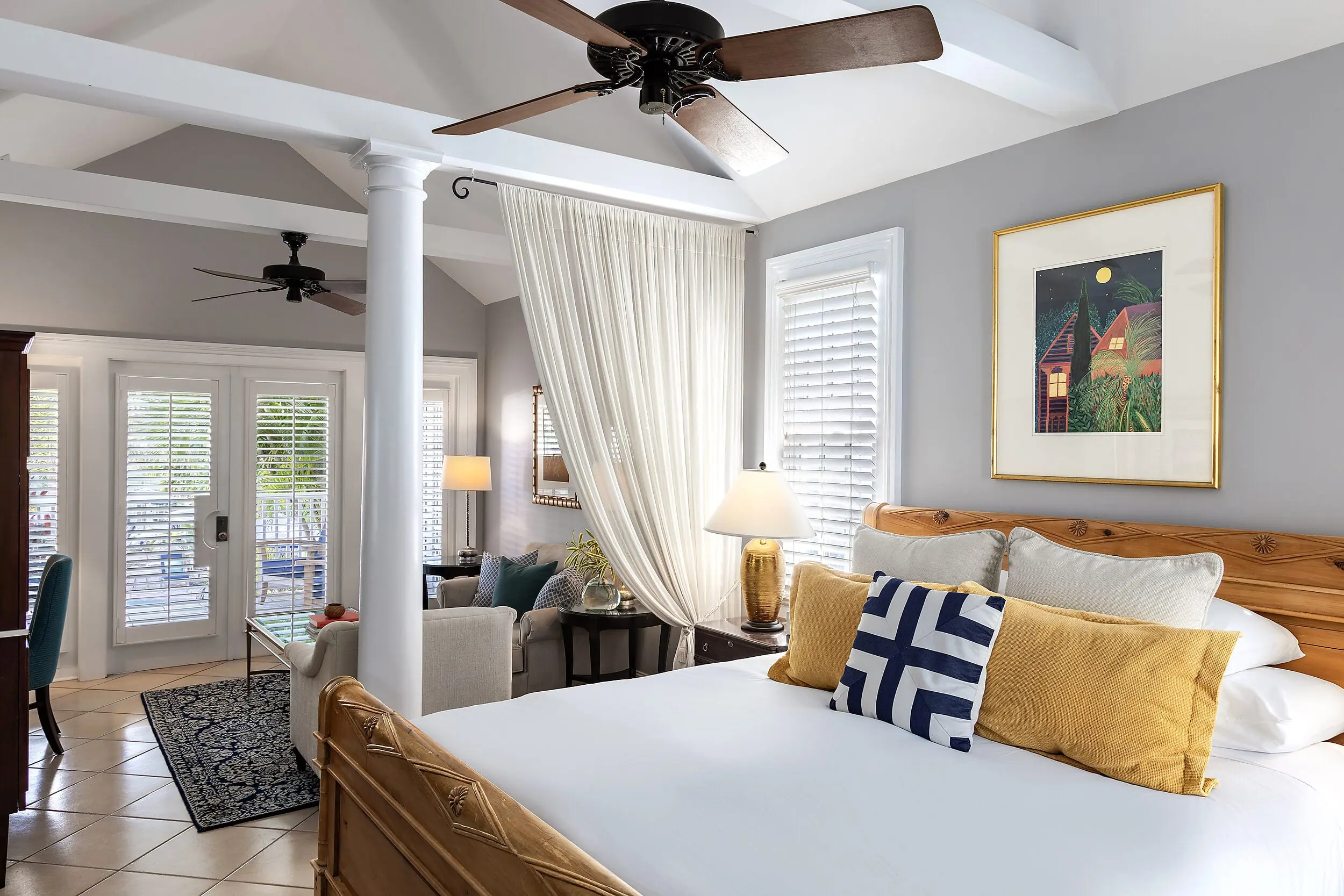 King bed with wood headboard and ceiling fans in a Marquesa Hotel Key West guestroom