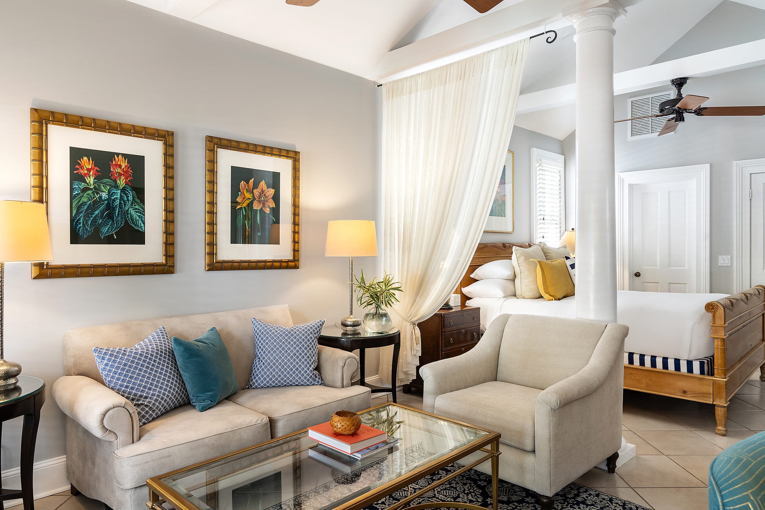 Sitting area with sofa and four-poster bed in a Marquesa Hotel Key West suite